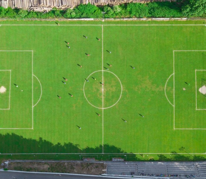 An aerial top view of a football field with players